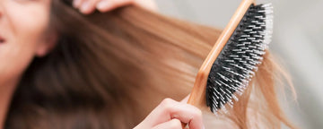 Kvinde redder sit hår med en hårbørste
