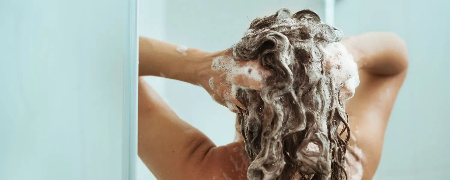 Kvinde vasker håret med shampoo til fedtet hår