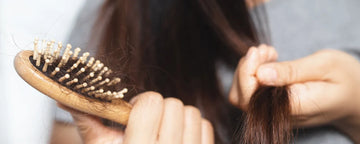 Kvinde med en hårbørste fyldt af hår