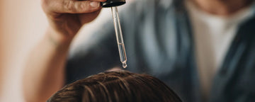 Mand bruger hårolie i håret