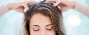 Kvinde klør sig i hovedbunden