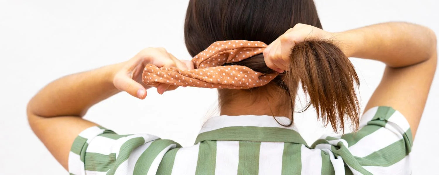 Kvinde tager en scrunchies i sit hår